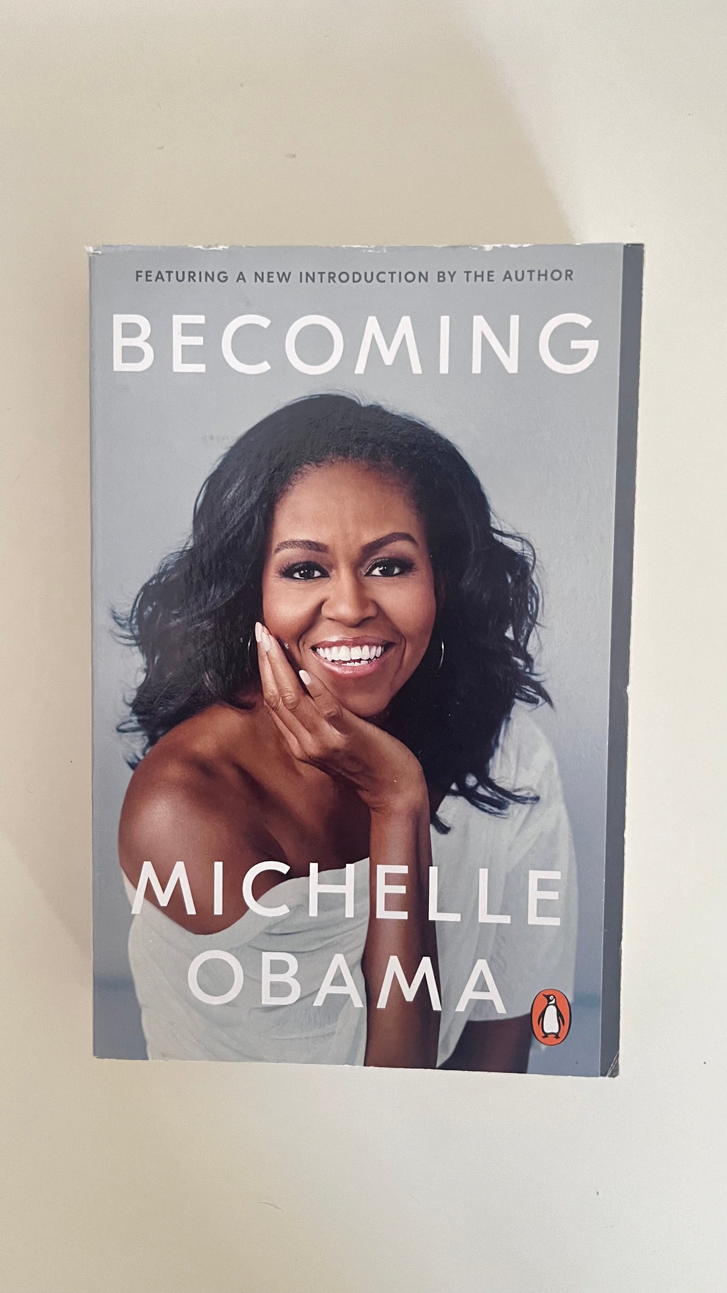 Paperback of Becoming by Michelle Obama featuring the iconic portrait of the former First Lady.