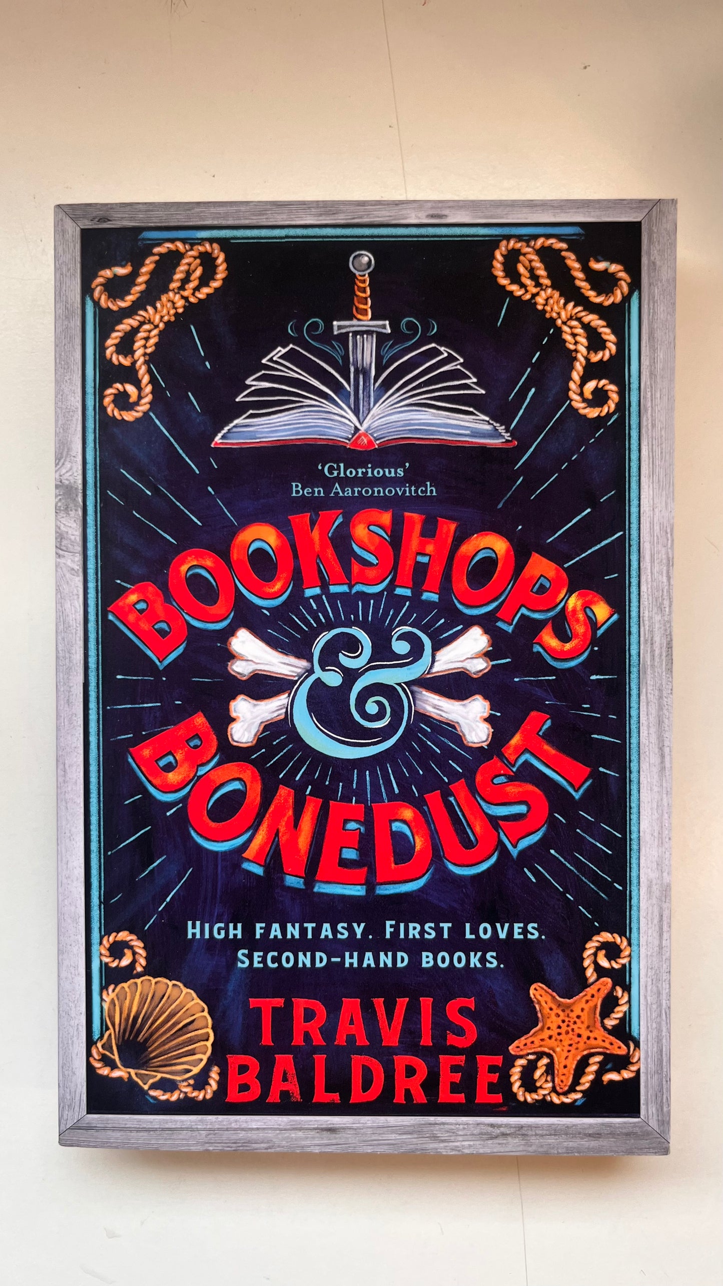 Framed poster for 'Bookshops & Bonedust' by Travis Baldree on a white Background.