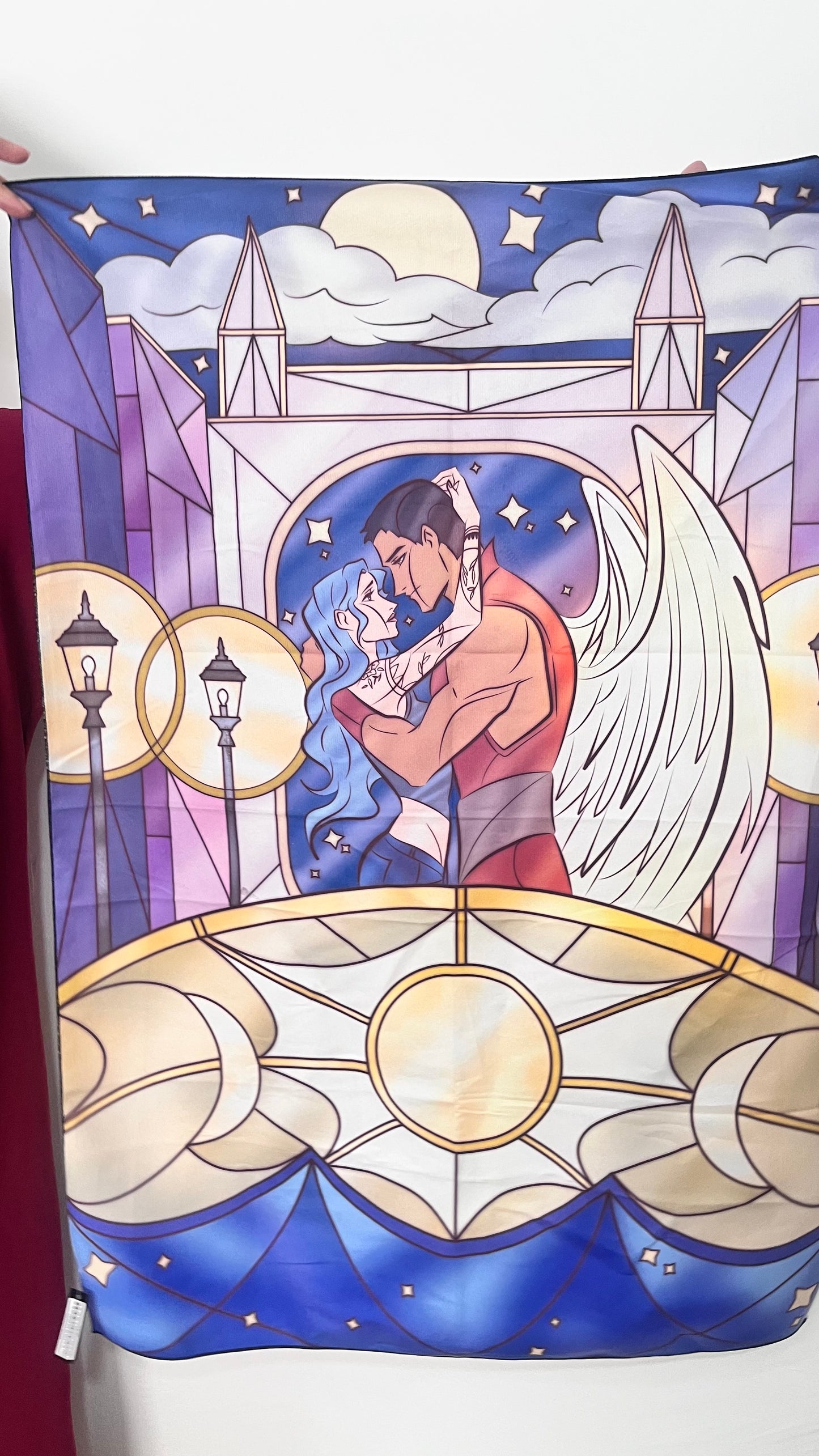 Stylized illustration of an angel holding a child against a celestial background.