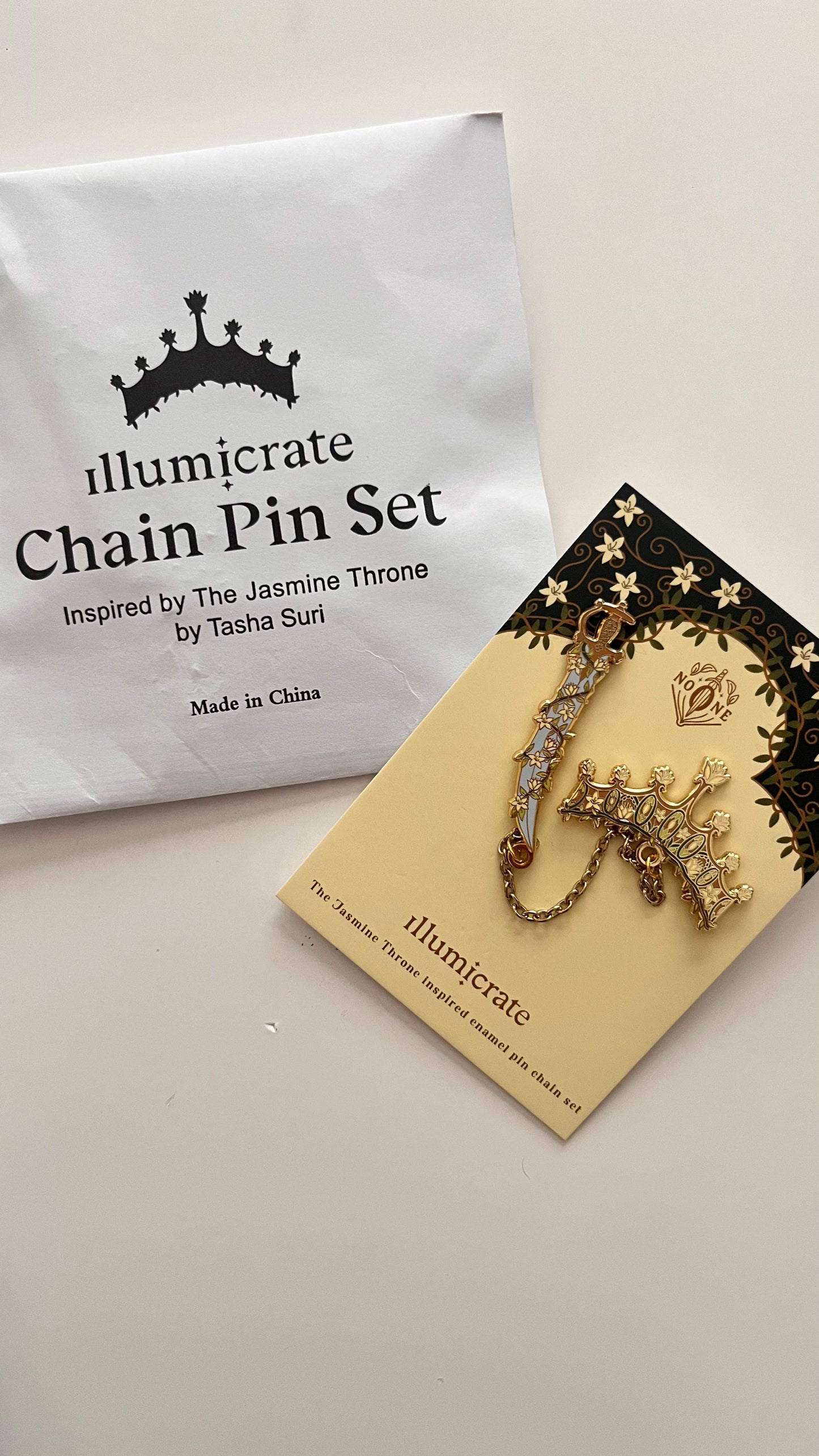 Illumicrate chain pin set on a branded card with packaging in the background