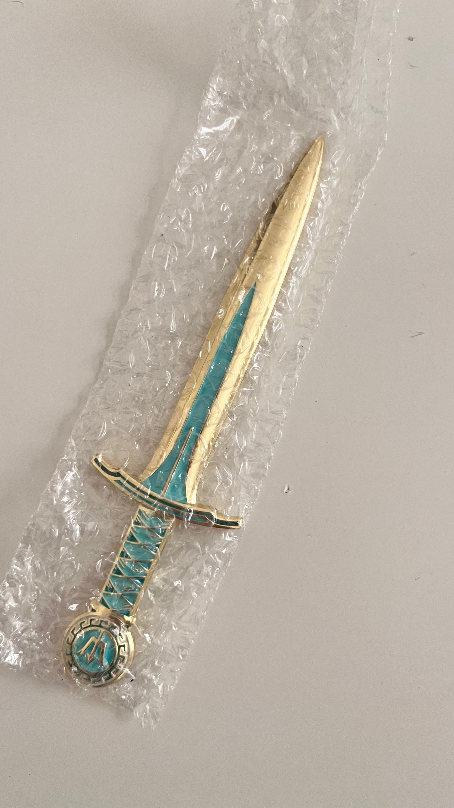 Decorative dagger with turquoise accents on a white background