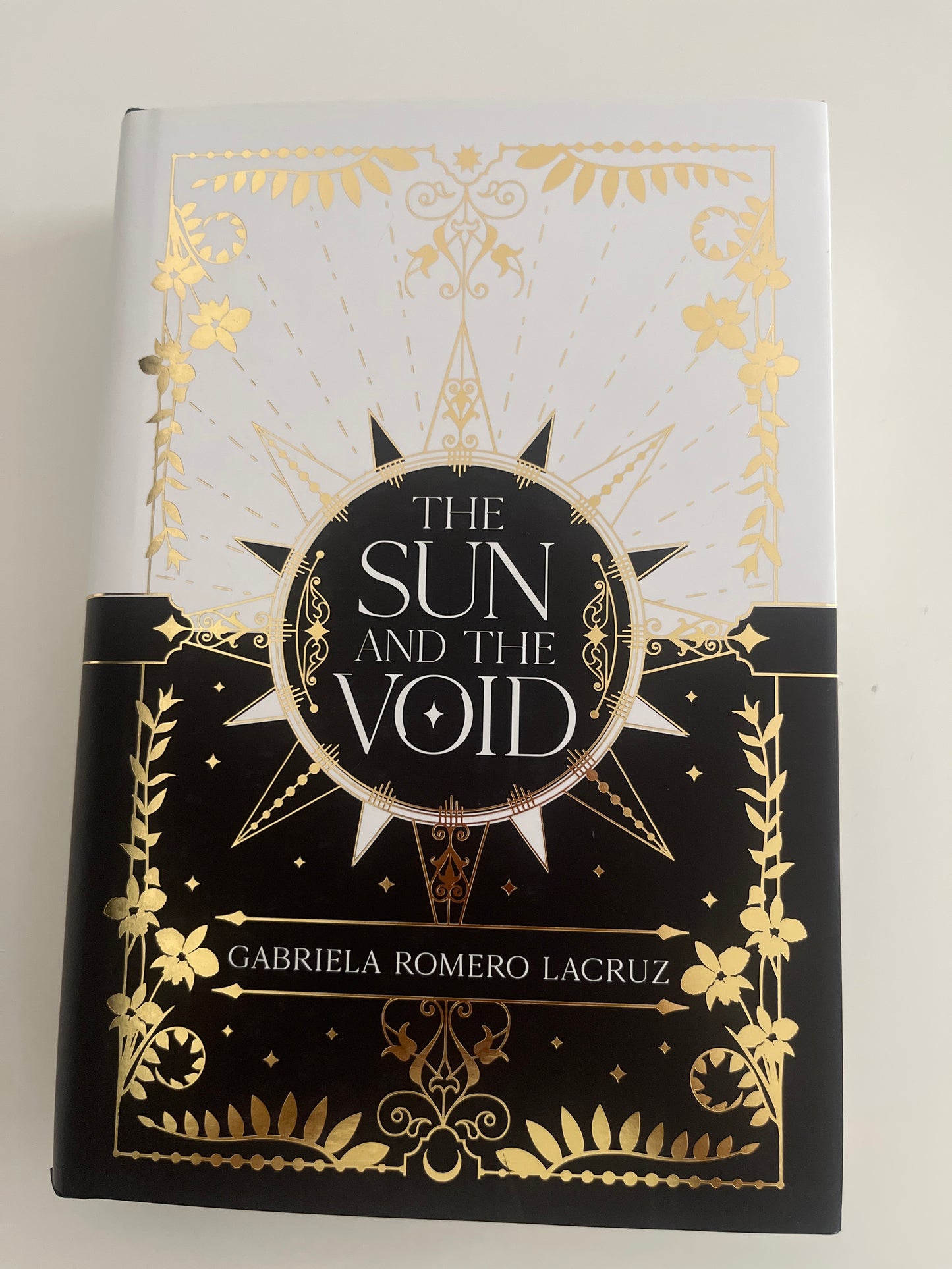 Book cover of 'The Sun and the Void' with gold and black design on a white background
