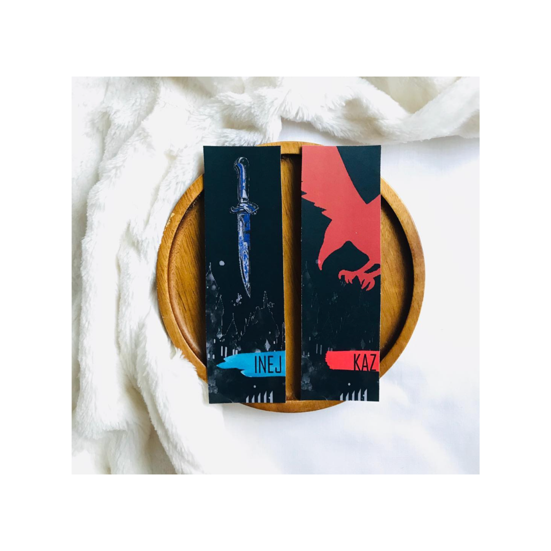 Two bookends with sword and eagle designs on a wooden plate with white fabric background