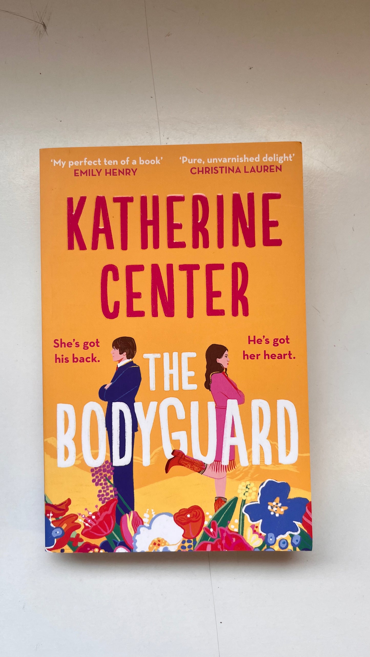 Book cover of 'The Bodyguard' by Katherine Center on a white wall