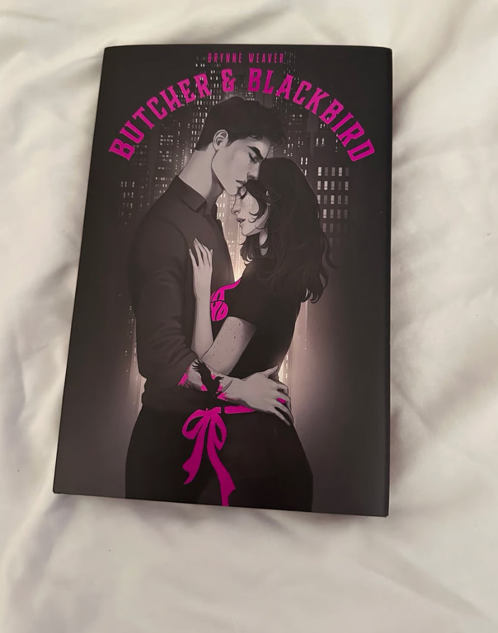 Book cover of 'Butcher & Blackbird' with a couple embracing against a city skyline.
