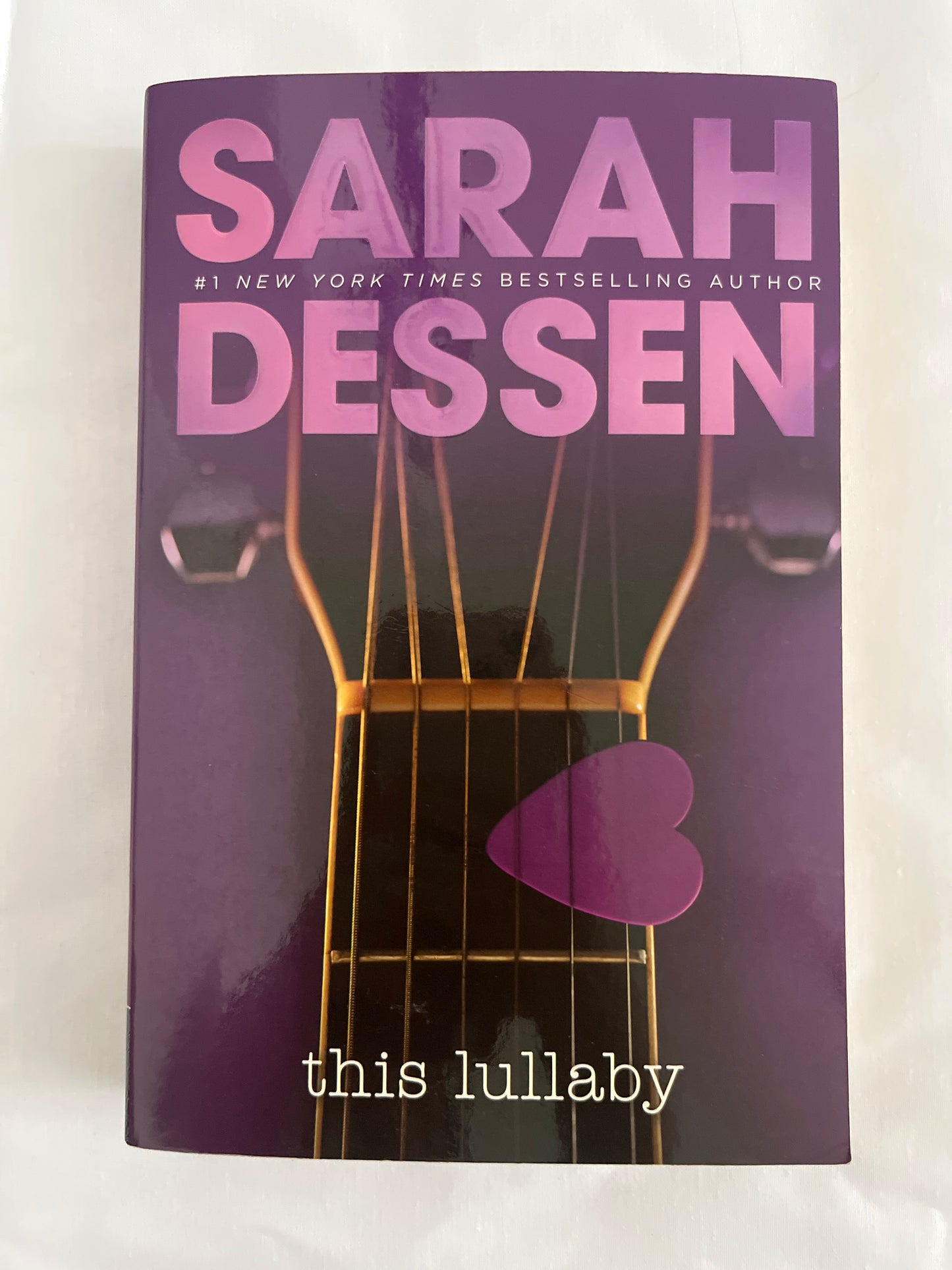 Cover of This Lullaby by Sarah Dessen with a dreamy pastel color scheme and a guitar as a central motif.