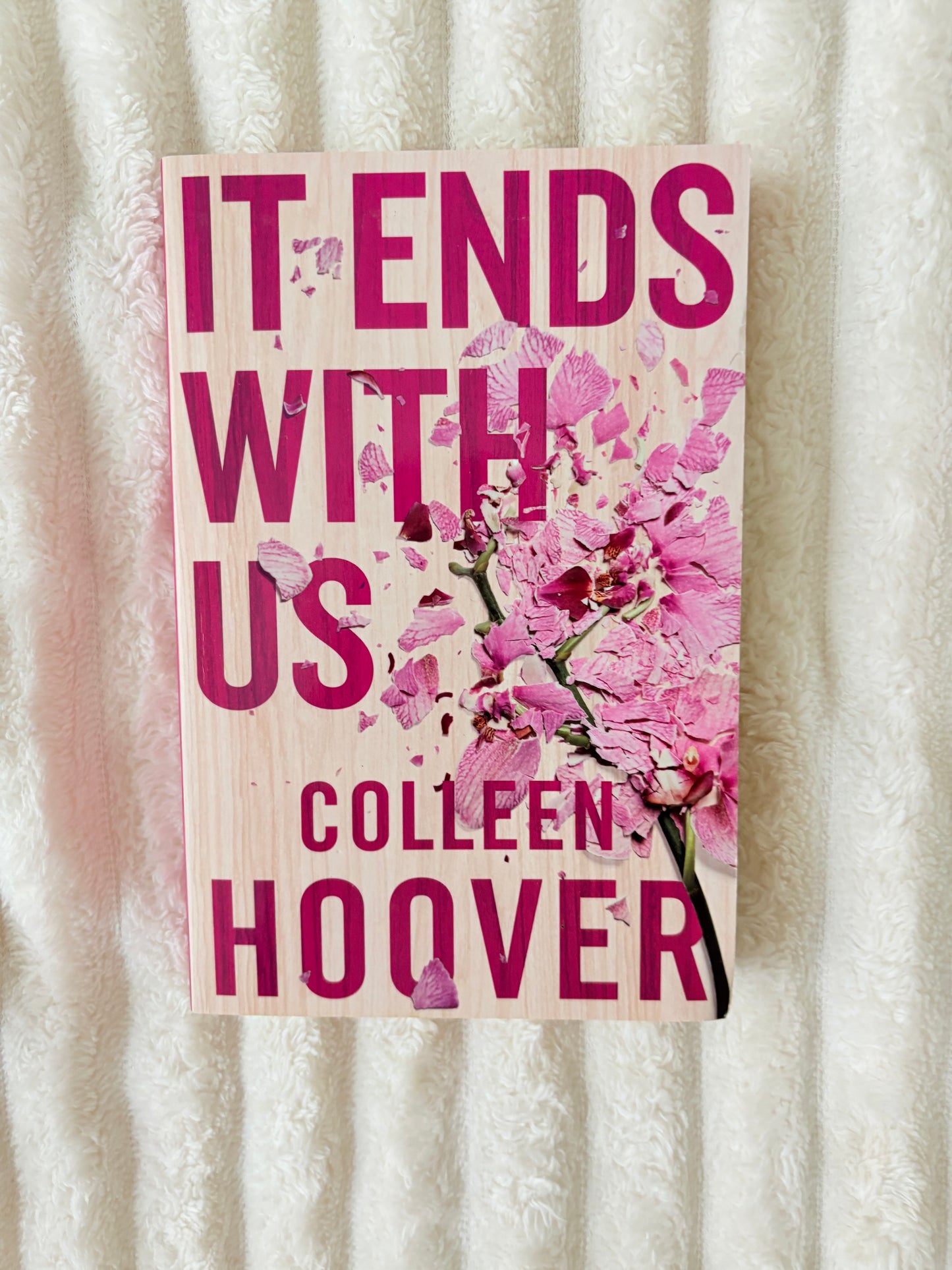 Book cover with pink floral design and text on a textured surface