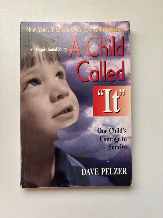 The book cover of 'A Child Called It' by Dave Pelzer, featuring a close-up photograph of a young boy's face against a purple cloudy background, with red and white title text.