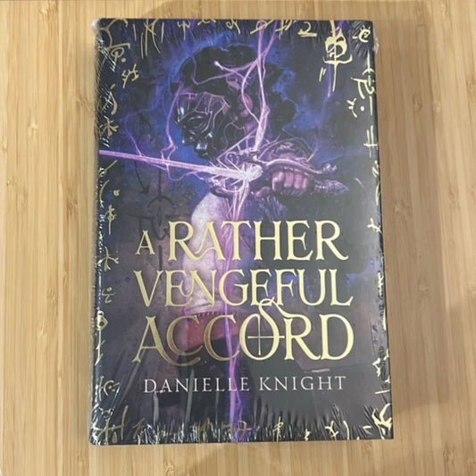 Book titled 'A Rather Vengeful Accord' by Danielle Knight on a wooden surface