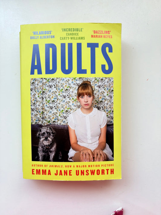 Book titled 'Adults' by Emma Jane Unsworth with a yellow cover and photo of a woman and dog on a white background.