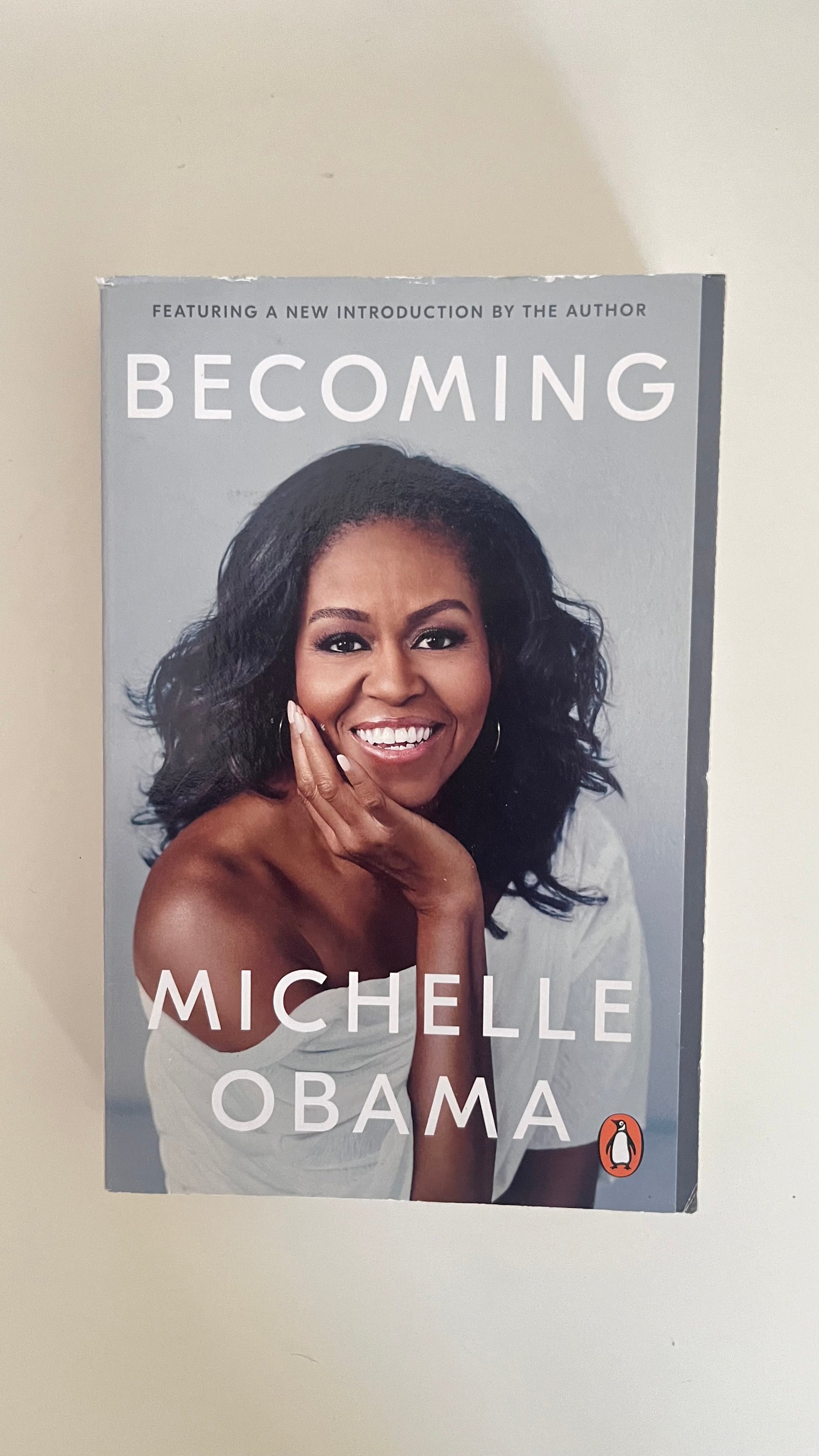 Paperback of Becoming by Michelle Obama featuring the iconic portrait of the former First Lady.

