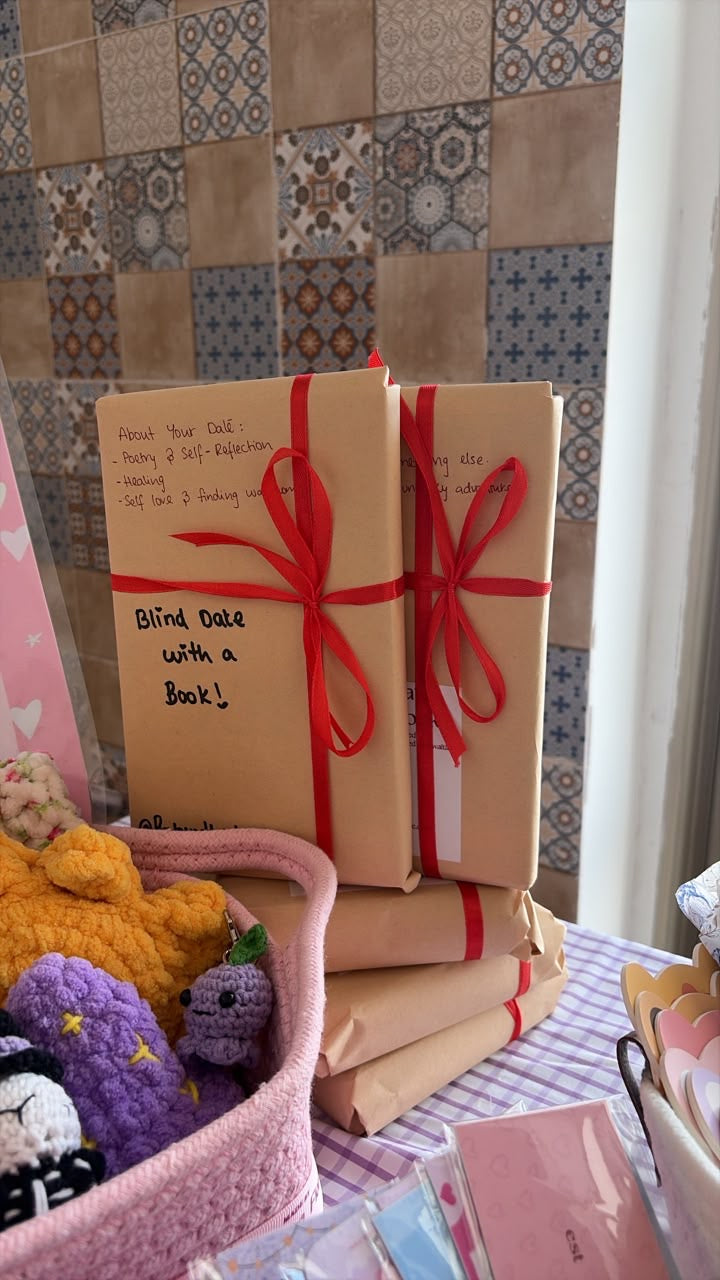 Two mystery books wrapped in recycled kraft paper with burgundy ribbons and Blind Date With a Book labels.