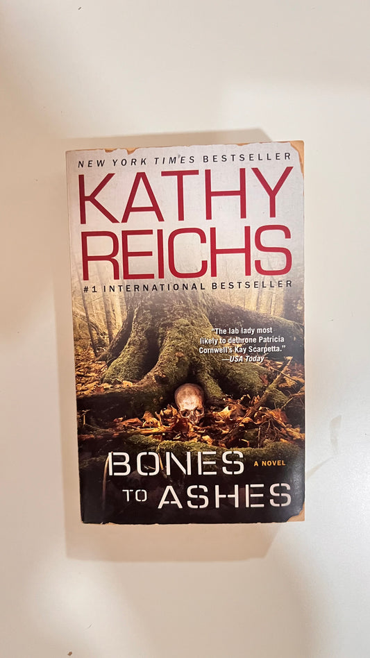 Paperback of Bones to Ashes by Kathy Reichs, with a chilling crime scene cover.

