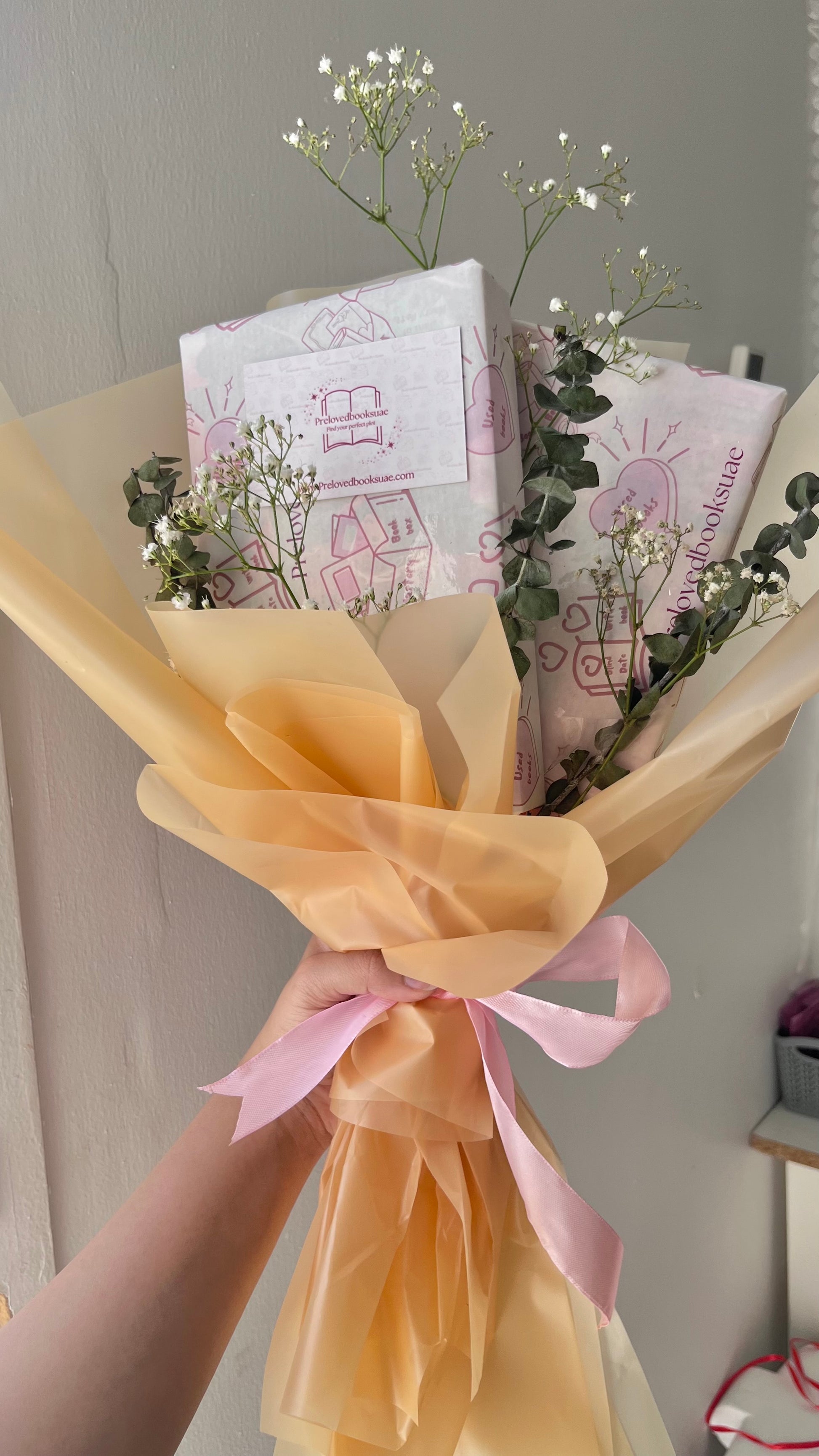 Aesthetic book bouquet wrapped in floral paper with handpicked preloved books from Preloved Books UAE.