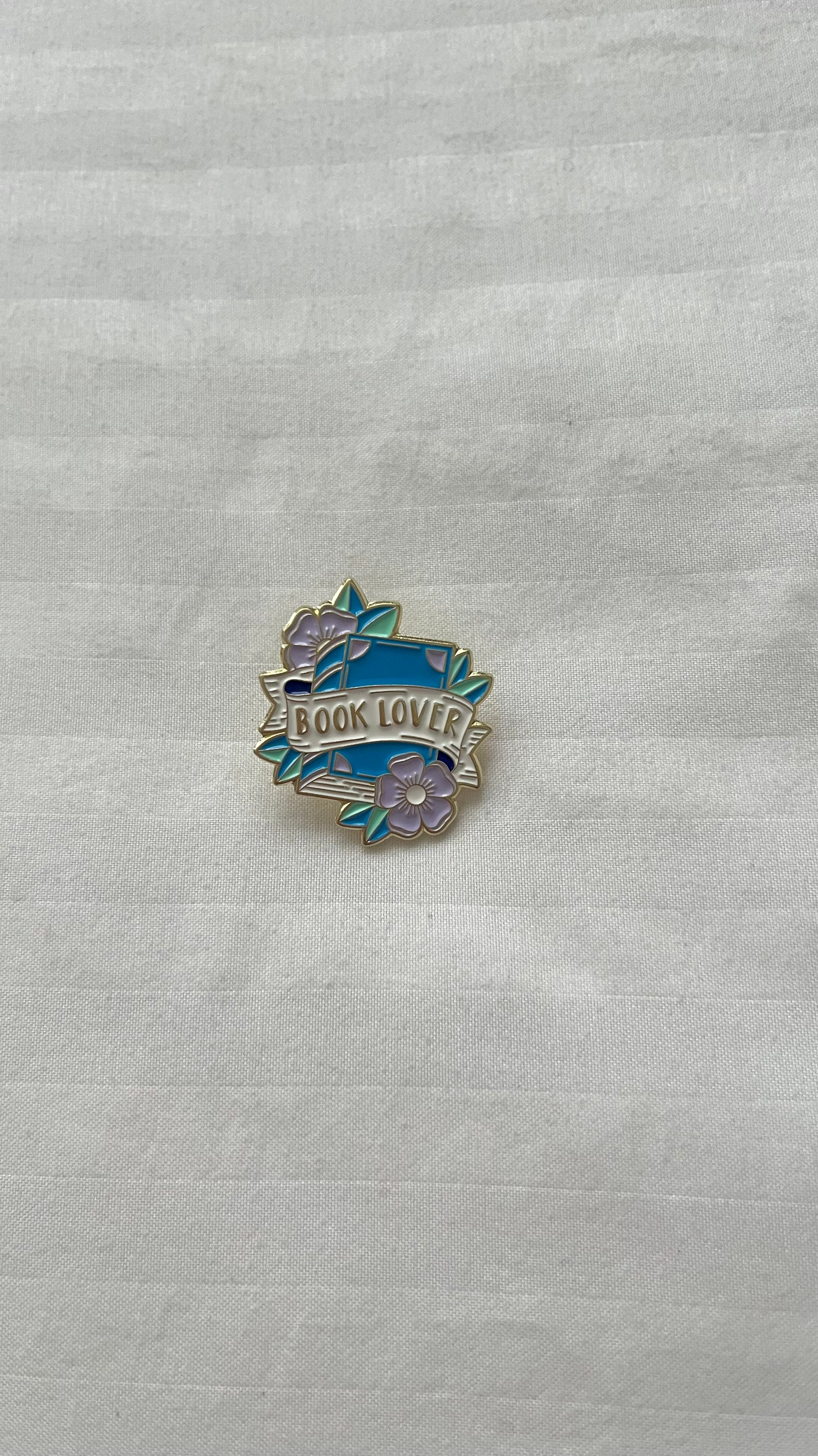 Booklover enamel pin with books and heart design

