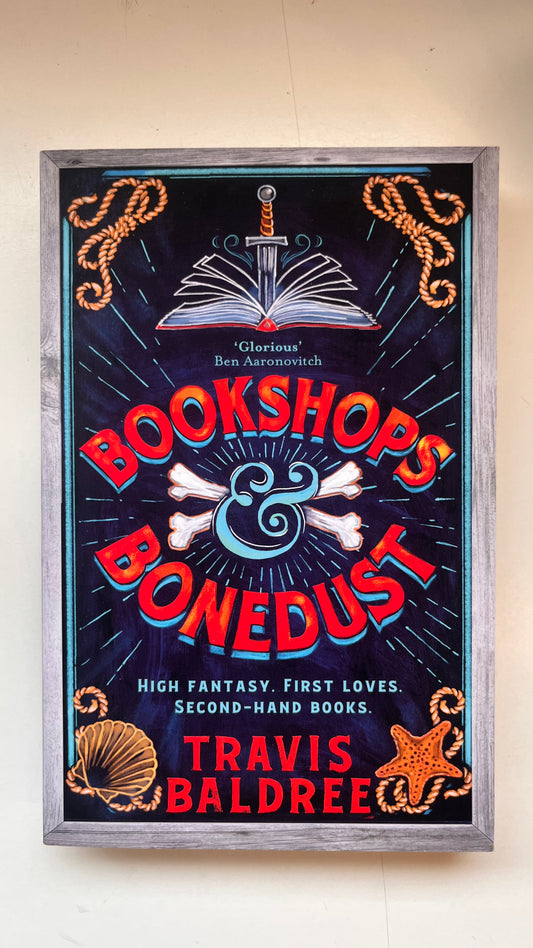 Framed poster for 'Bookshops & Bonedust' by Travis Baldree on a white Background.