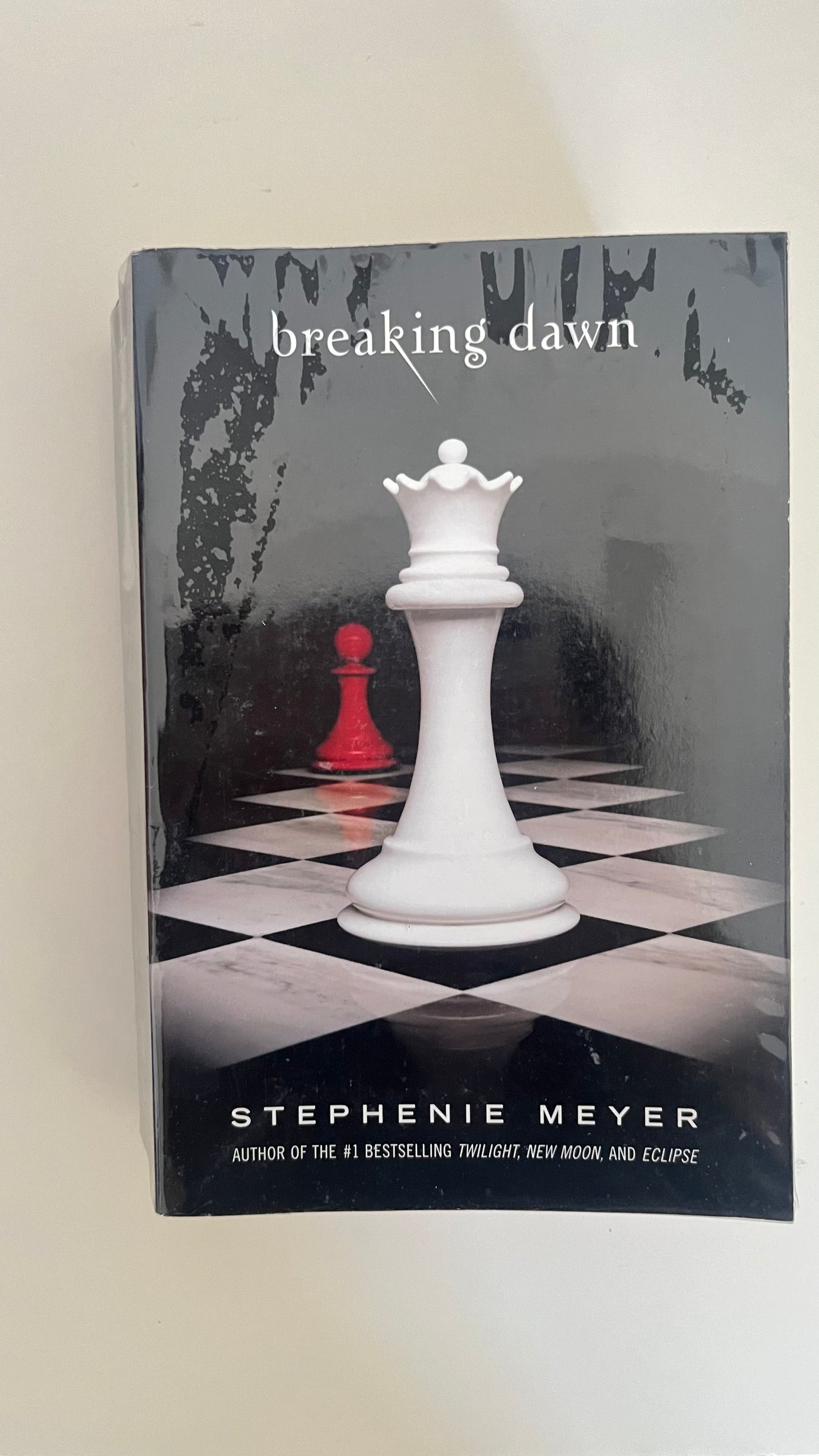 Paperback of Breaking Dawn by Stephenie Meyer with the signature chess piece cover design symbolizing power and choice.

