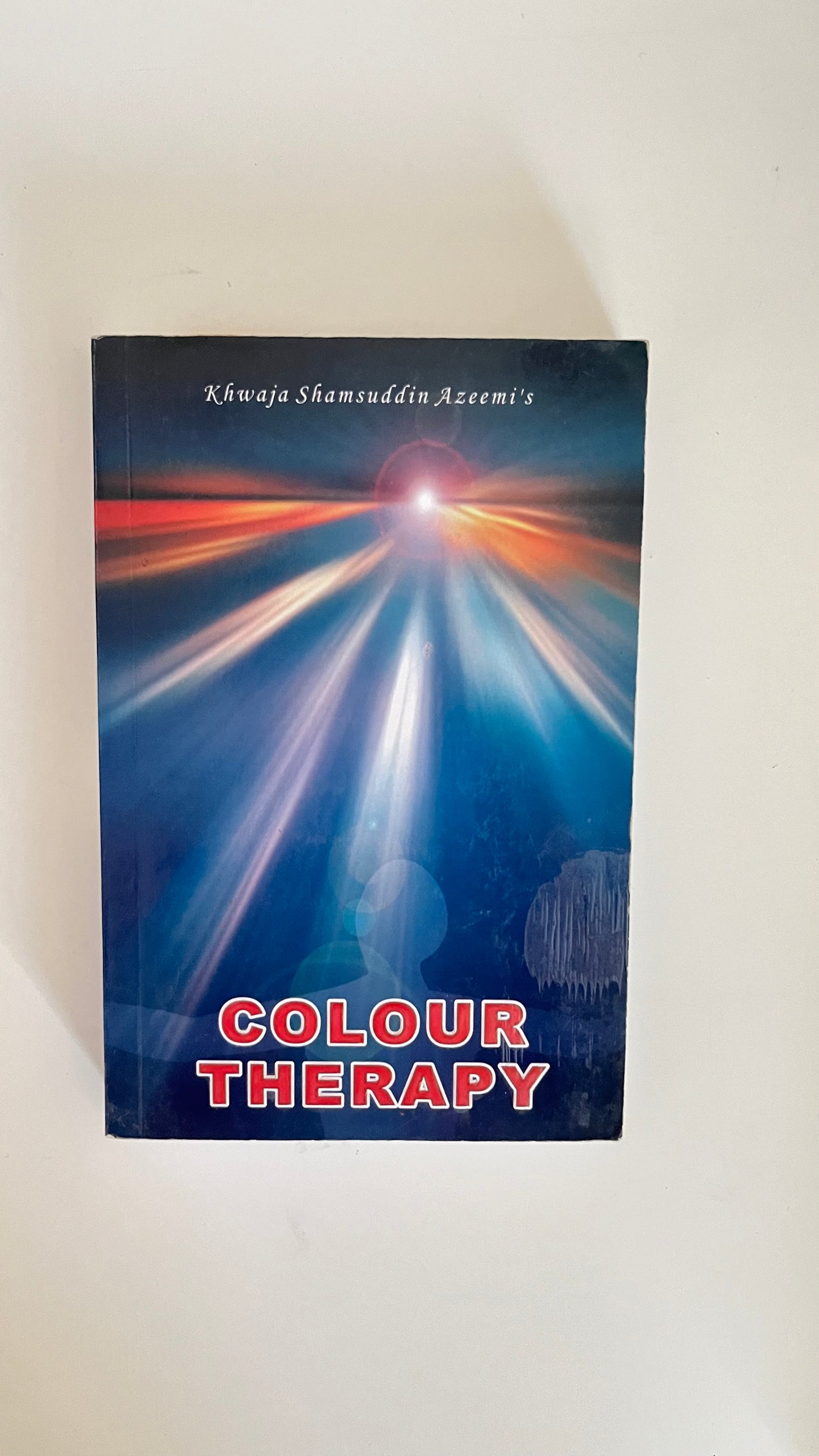 Paperback edition of Color Therapy by Khawaja Shamsuddin Azeemi featuring a rainbow-themed design symbolizing chakra and energy alignment.

