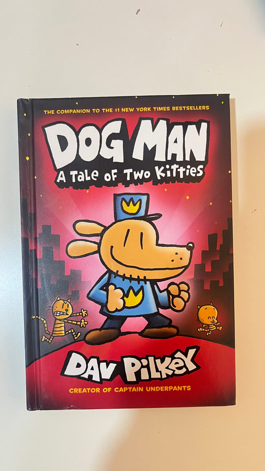 Hardback edition of Dog Man: A Tale of Two Kitties by Dav Pilkey with a vibrant cartoon-style cover featuring Dog Man and mischievous kittens.

