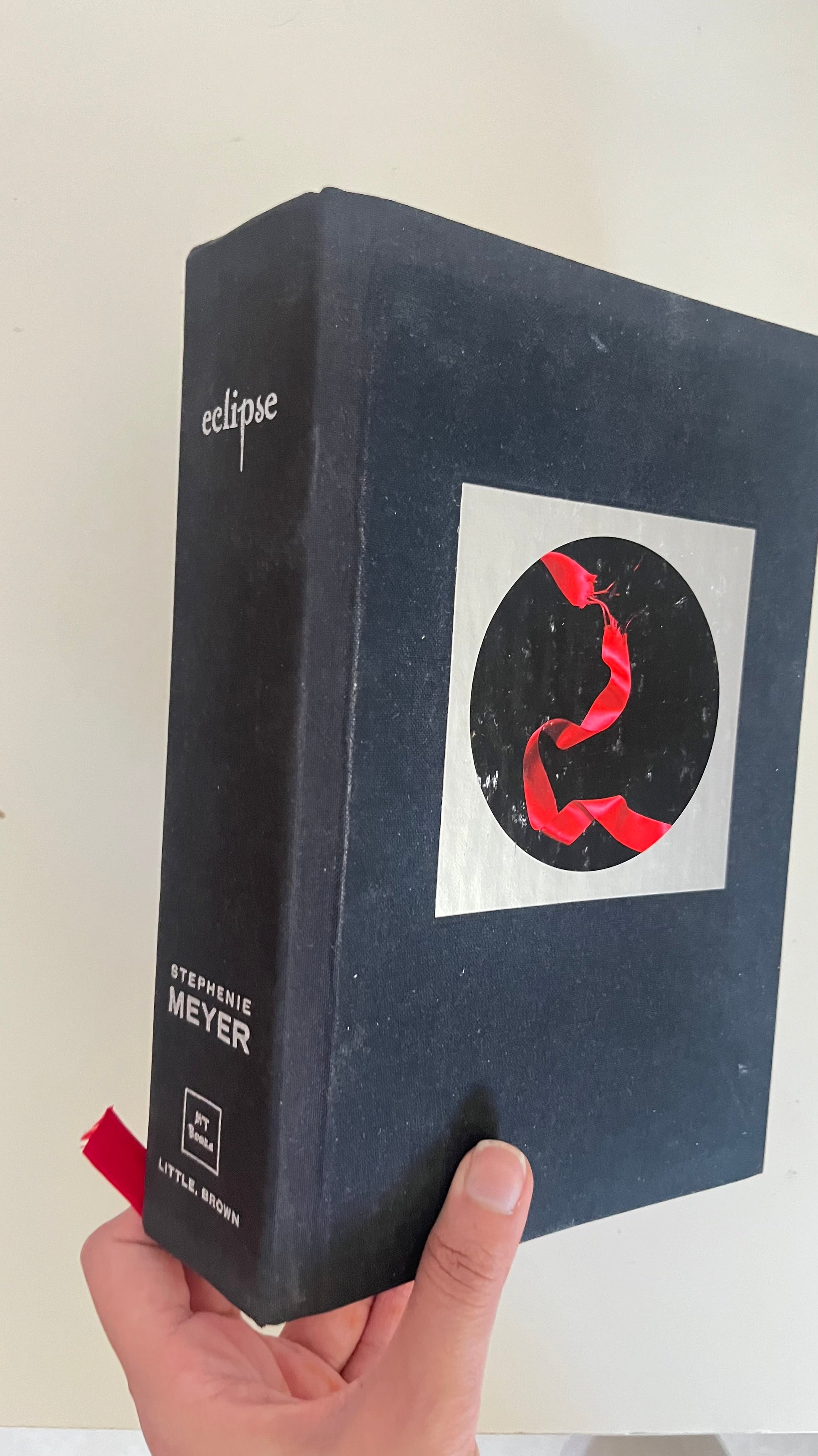 Paperback edition of Eclipse by Stephenie Meyer with the torn red ribbon cover symbolizing difficult choices.

