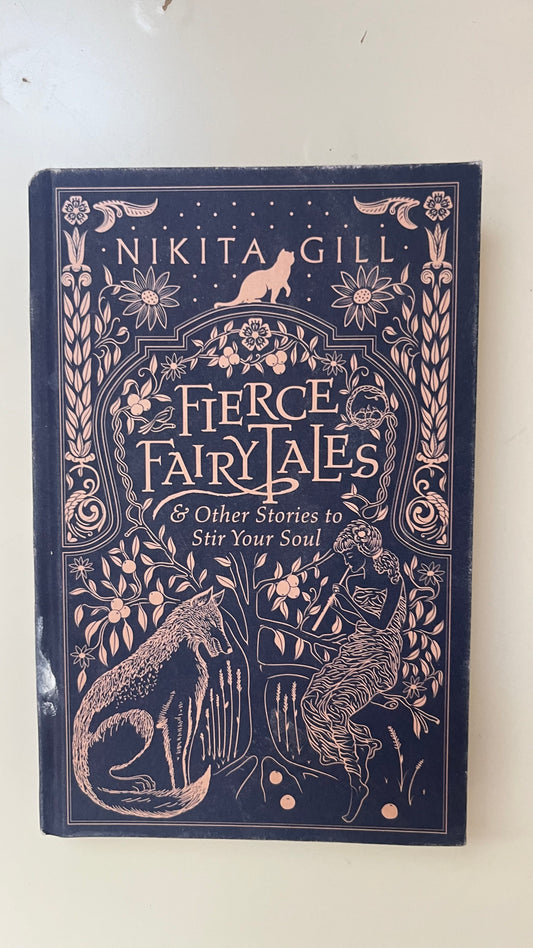 Hardcover edition of Fierce Fairytales by Nikita Gill featuring a deep blue cover with celestial and fairytale-inspired illustrations.

