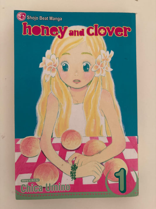 Manga book cover of 'Honey and Clover' with a character holding peaches on a blue and pink background.