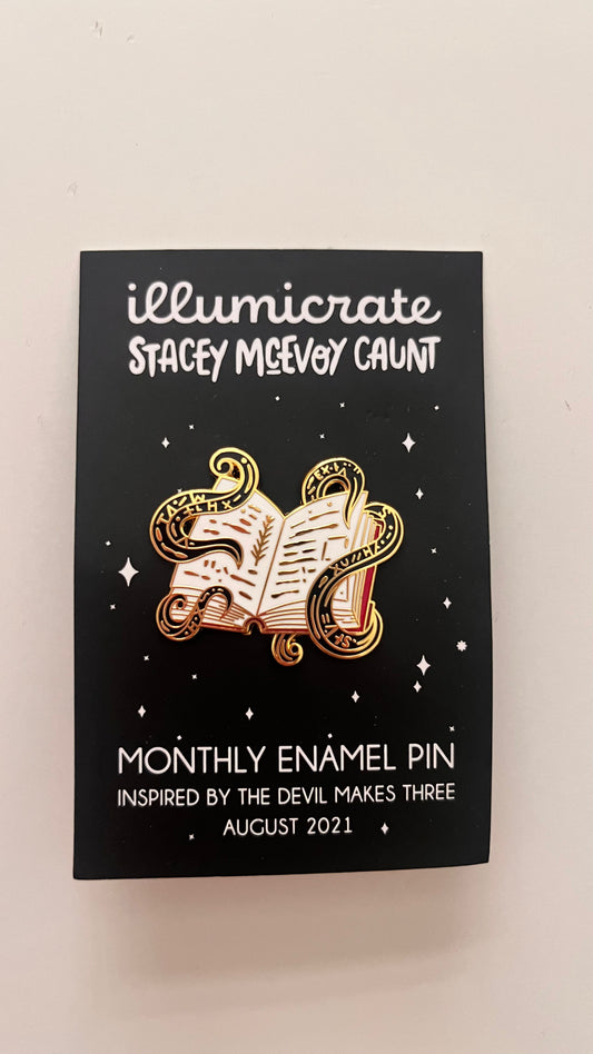 Enamel pin packaging with 'illumicrate' branding and design details.