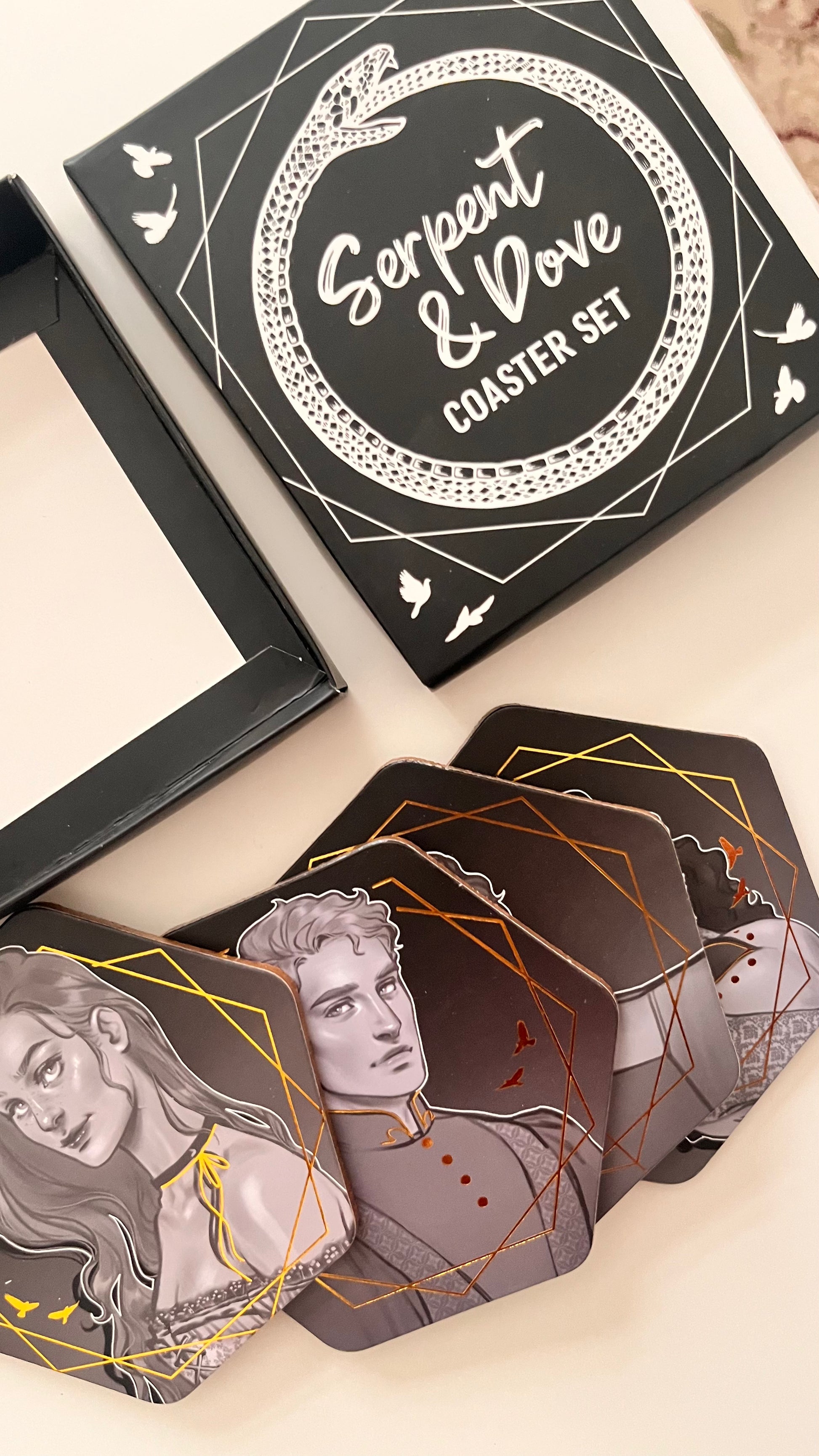 Serpent & Dove coaster set with artistic designs on a light background