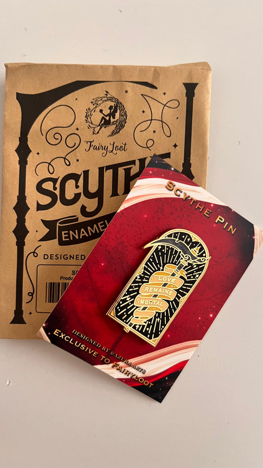 Scythe enamel pin with packaging on a white background