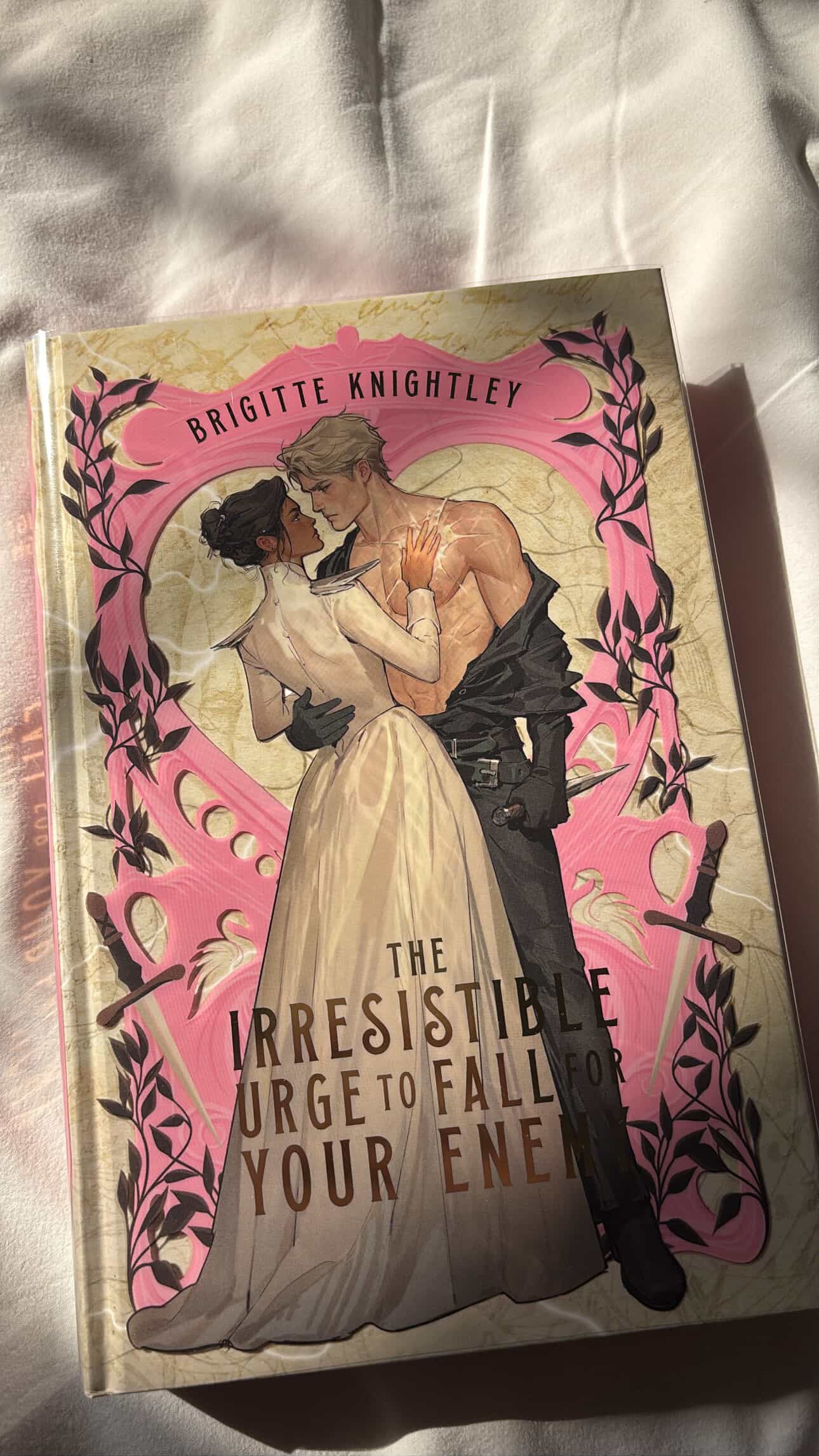Book cover with illustration of a couple embracing, featuring the title 'The Irresistible Urge to Fall for Your Enemy' by Brigitte Knightley.