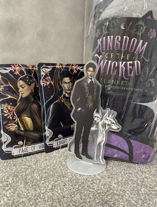 Card game components including cards and a figurine with 'Kingdom of the Wicked' packaging.