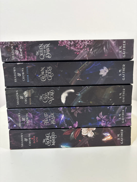 Five darkly colored book spines with floral designs and 'Gather' branding on a white background.