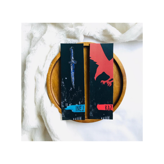 Two bookends with sword and eagle designs on a wooden plate with white fabric background