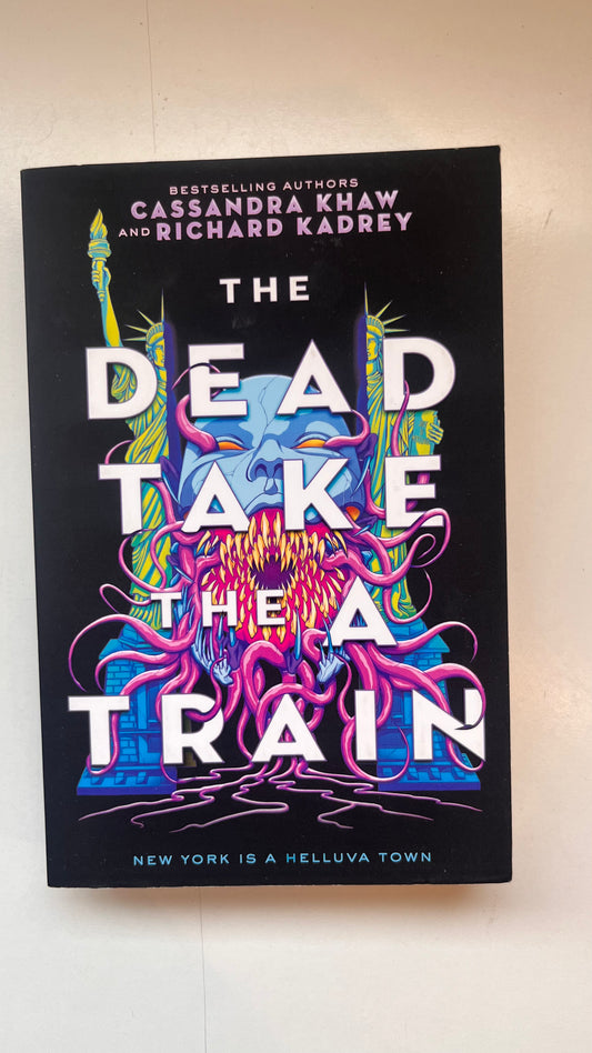 Book cover of 'The Dead Take the A Train' by Cassandra Khaw and Richard Kadrey on a white background