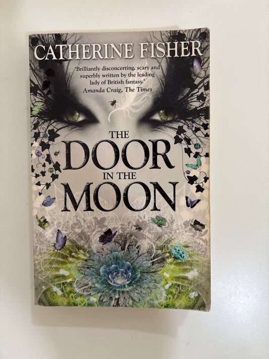 Book titled 'The Door in the Moon' by Catherine Fisher with decorative cover on a white background