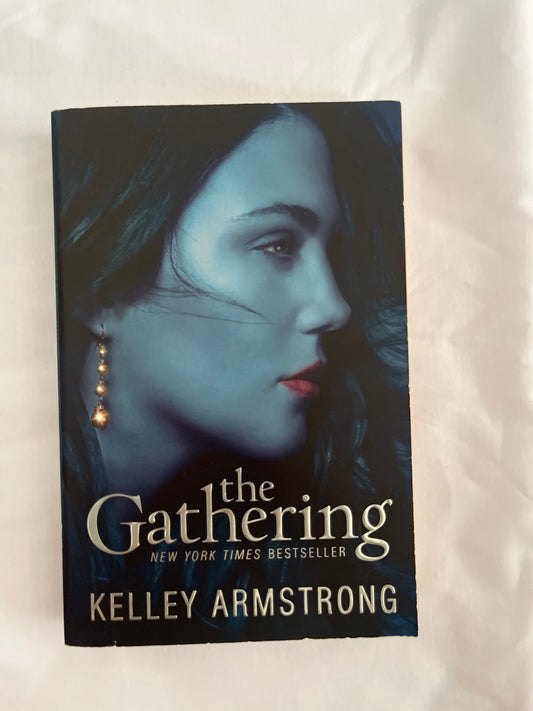 The Gathering by Kelley Armstrong featuring a forested background with a mysterious teen girl staring out intensely

