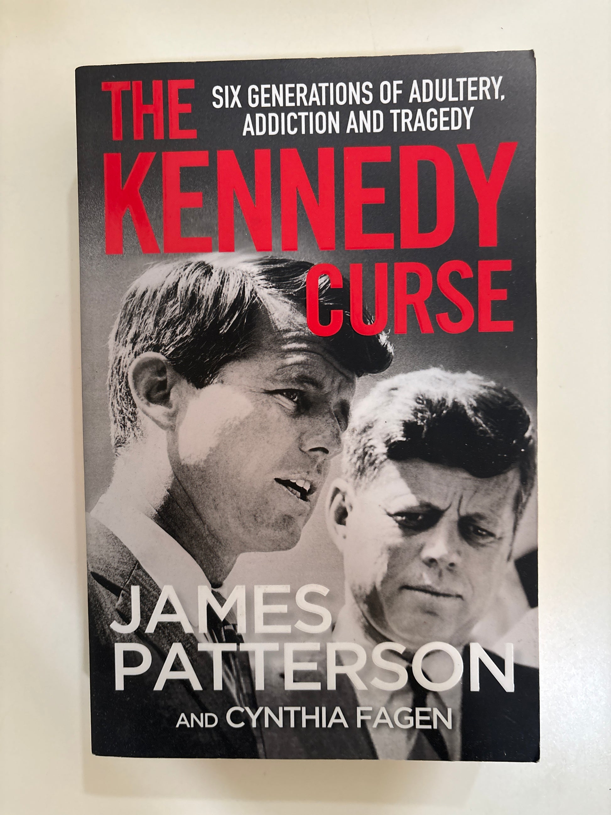 Book cover of 'The Kennedy Curse' with black and white photo and red text on a white background