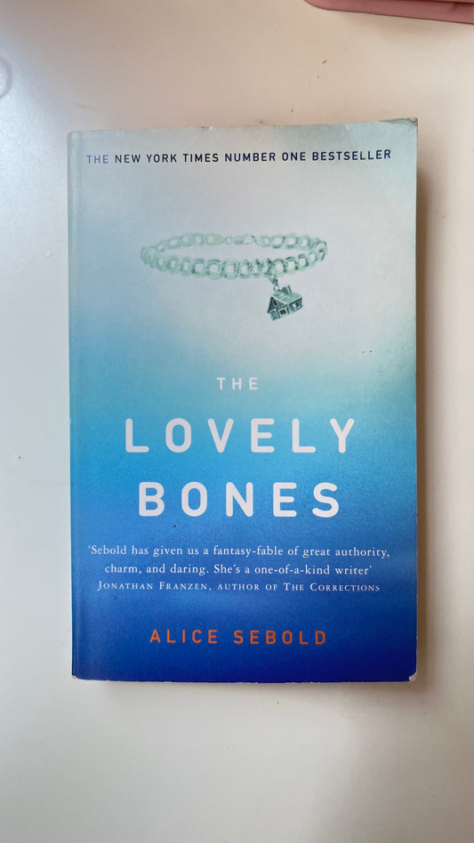 Paperback of The Lovely Bones by Alice Sebold with hauntingly beautiful cover art.

