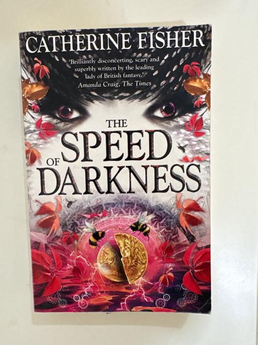 Book cover of 'The Speed of Darkness' by Catherine Fisher with artistic design elements on a white background.
