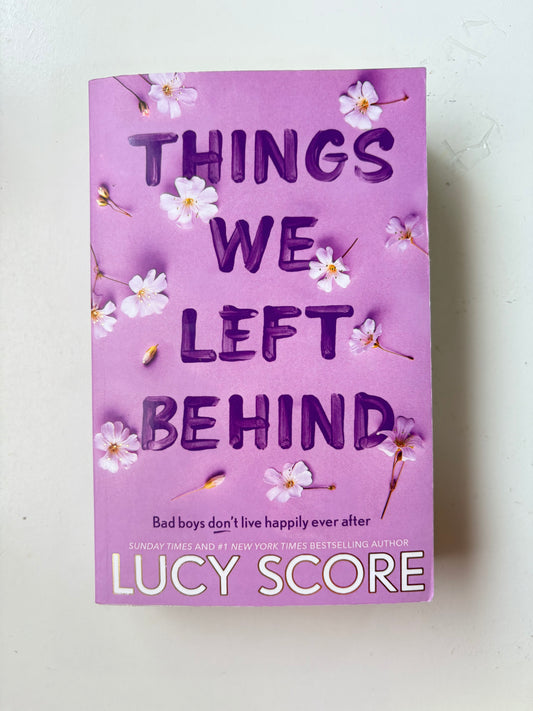Book titled 'Things We Left Behind' by Lucy Score with decorative flowers on a light background