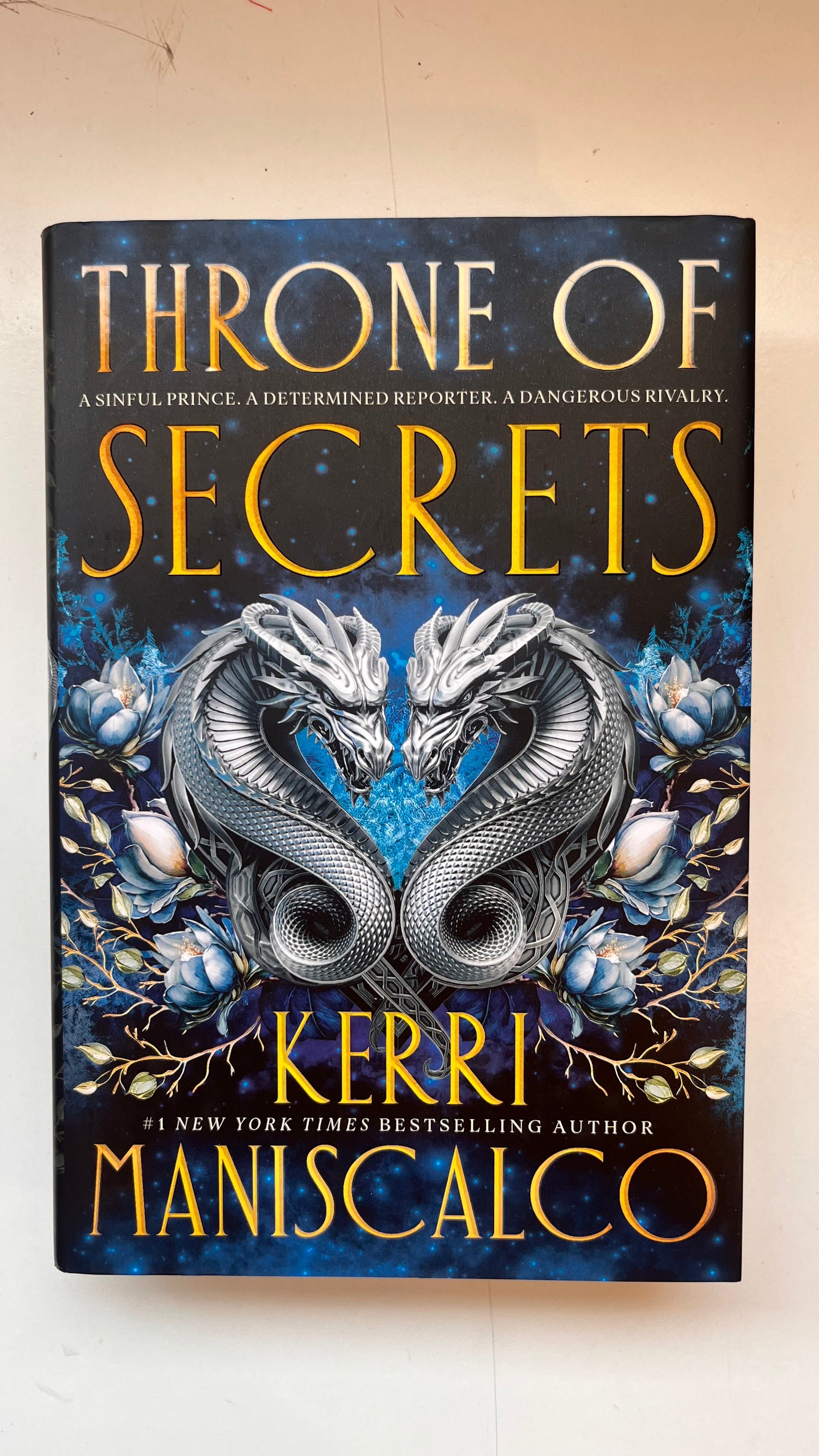 Book cover of 'Throne of Secrets' by Kerri Maniscalco with dragons on a dark background.