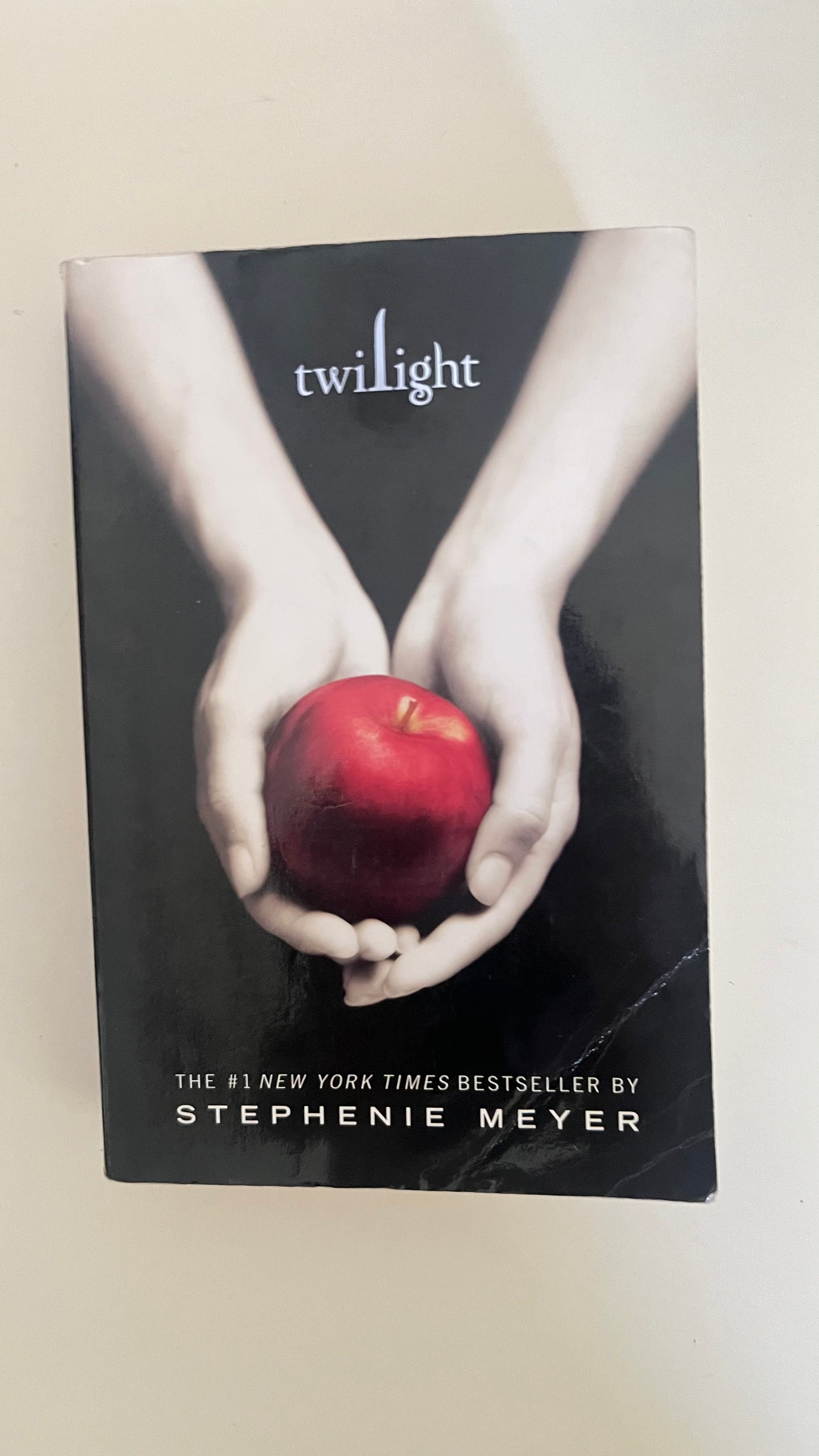 Paperback edition of Twilight by Stephenie Meyer featuring the iconic hands-holding-apple cover.

