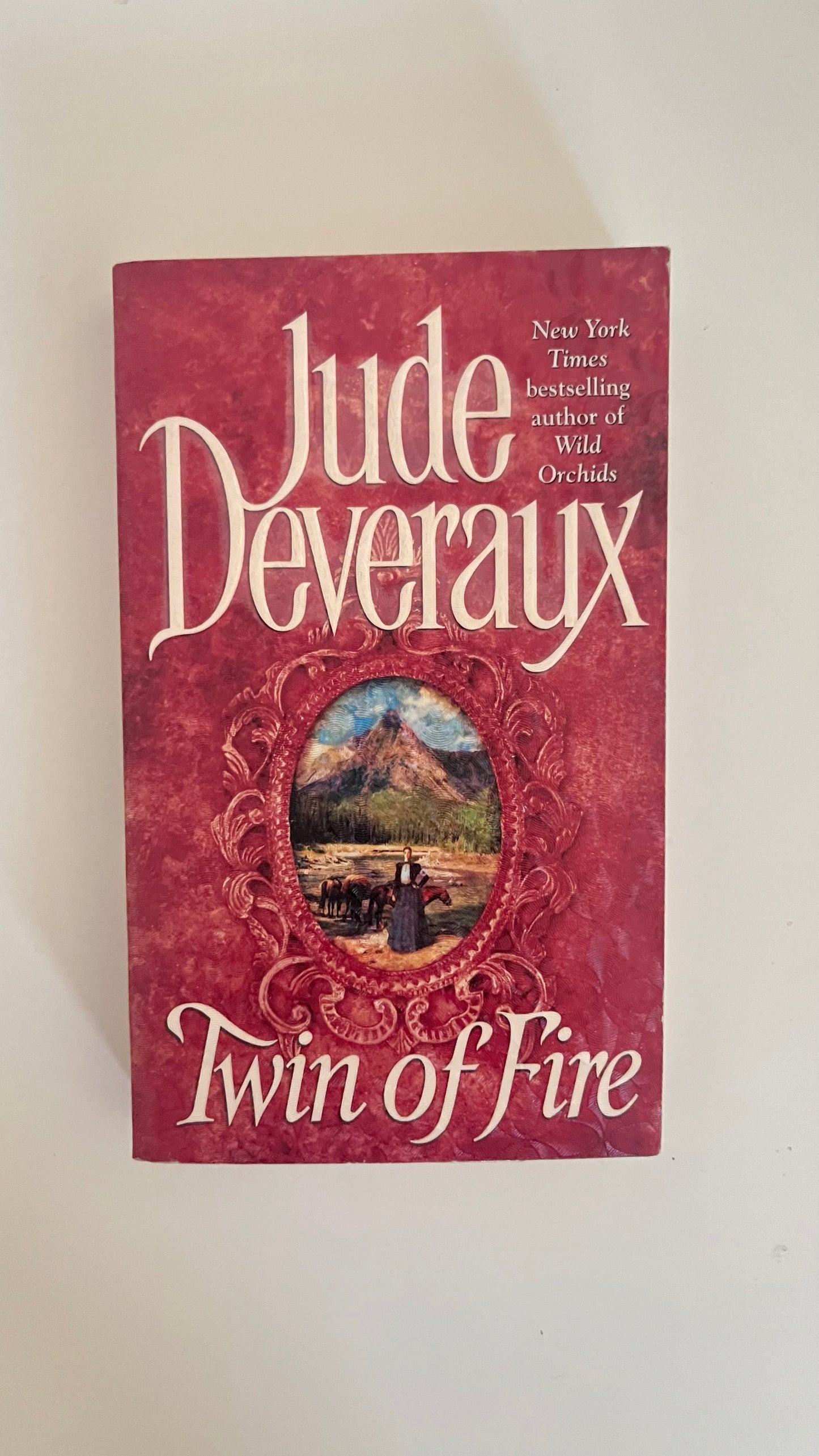 Paperback of Twin of Fire by Jude Deveraux with vintage romantic artwork of a passionate 1800s couple.

