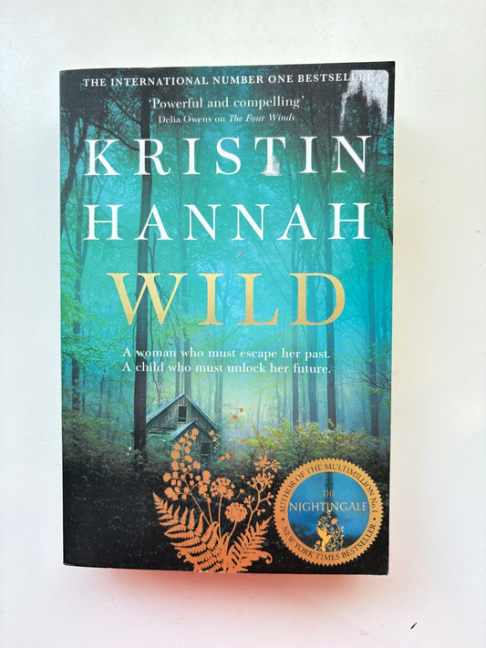 Book titled 'Wild' by Kristin Hannah with a blue and green cover on a white background