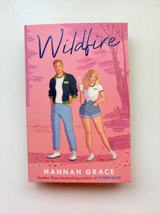 Book cover of 'Wildfire' by Hannah Grace with illustrations of a man and woman on a pink background.