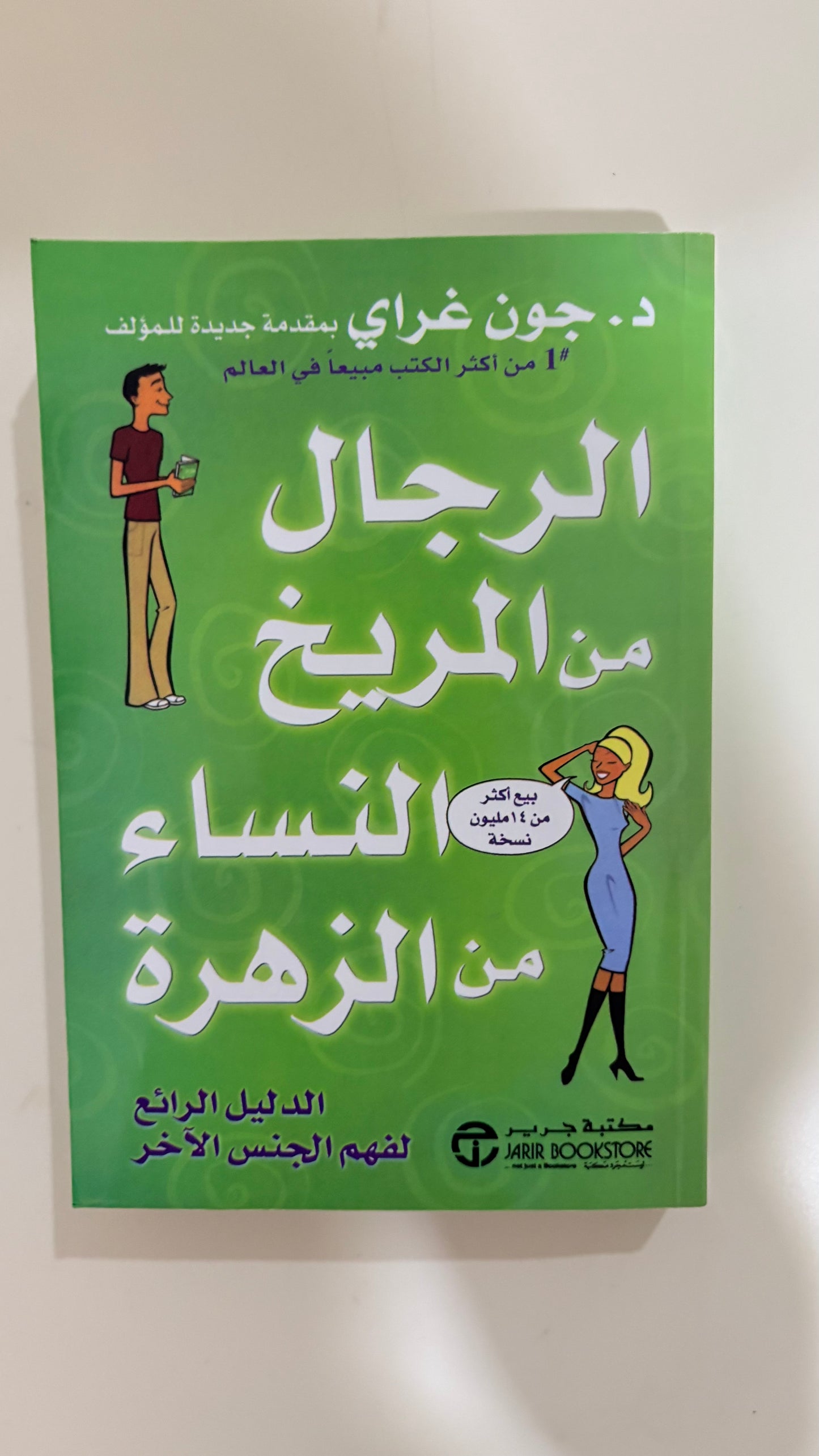 A green book cover with Arabic text, featuring illustrated figures and the title 'The Men Who Raised Women' by Dr. Jon Gray.