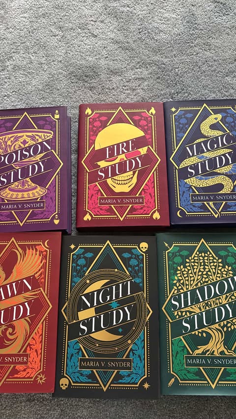 Five books from the 'Poison Study' series by Maria V. Snyder on a gray surface.